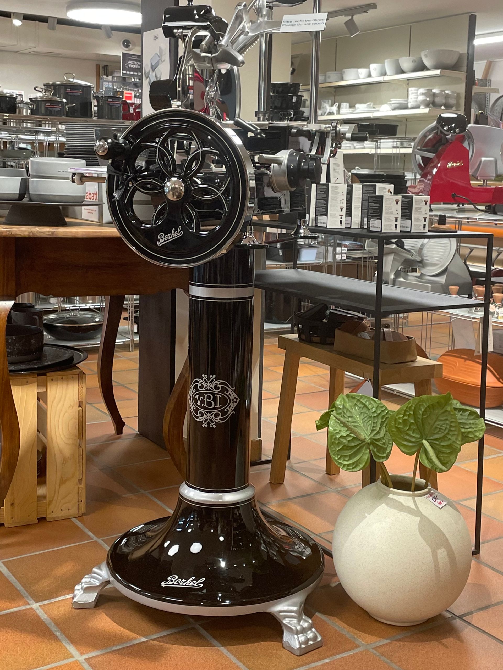 In einem Laden steht eine schwarze Maschine auf einem gefliesten Boden.