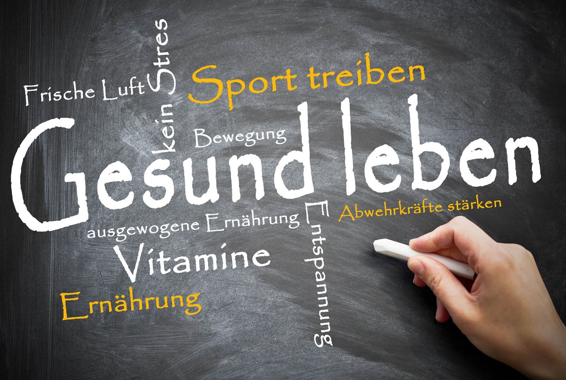 Eine Person schreibt das Wort „Gesundleben“ auf eine Tafel