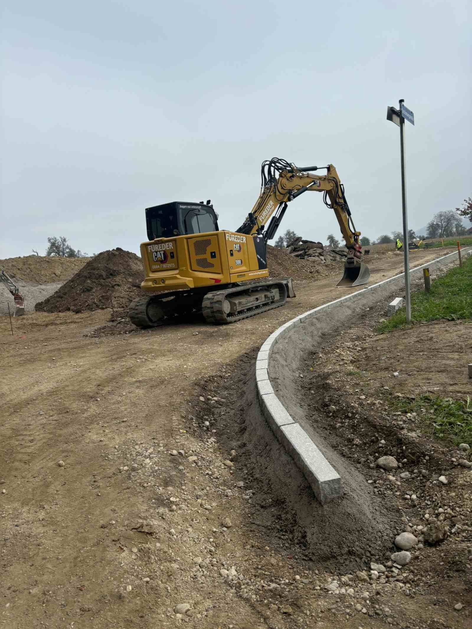 Ein Muldenkipper und ein Bagger sind auf einem Feld geparkt.