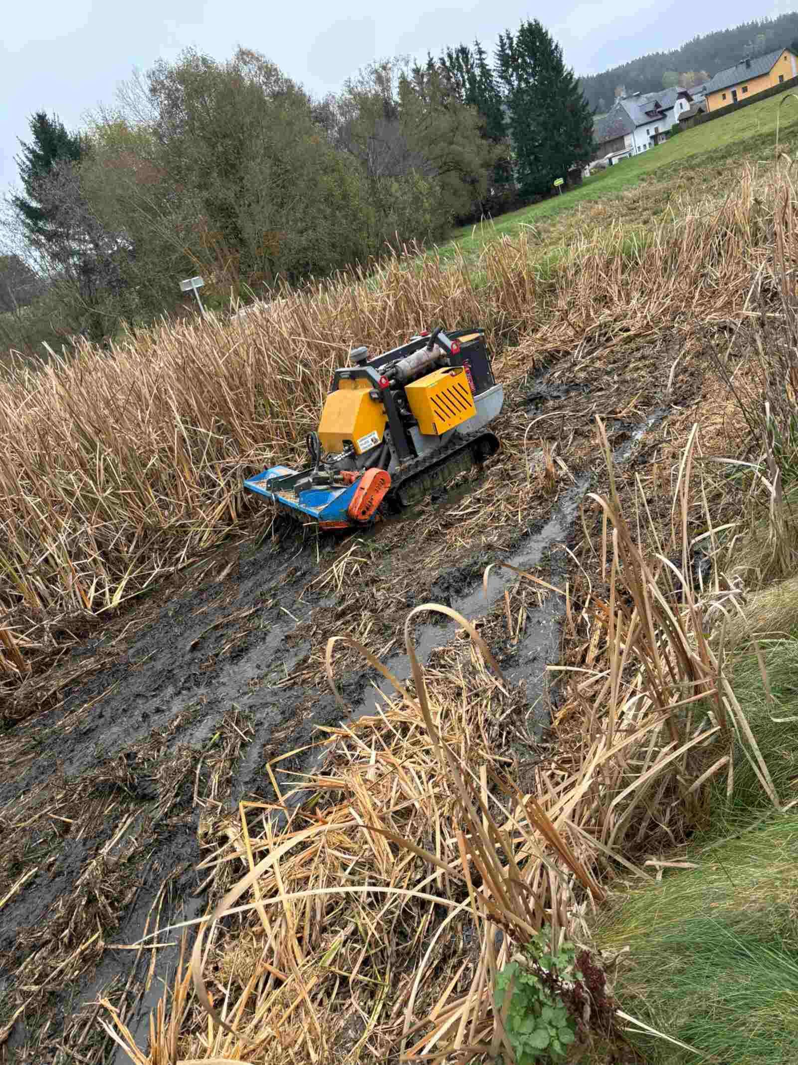 Ein Mulcher fährt durch ein schlammiges Feld.