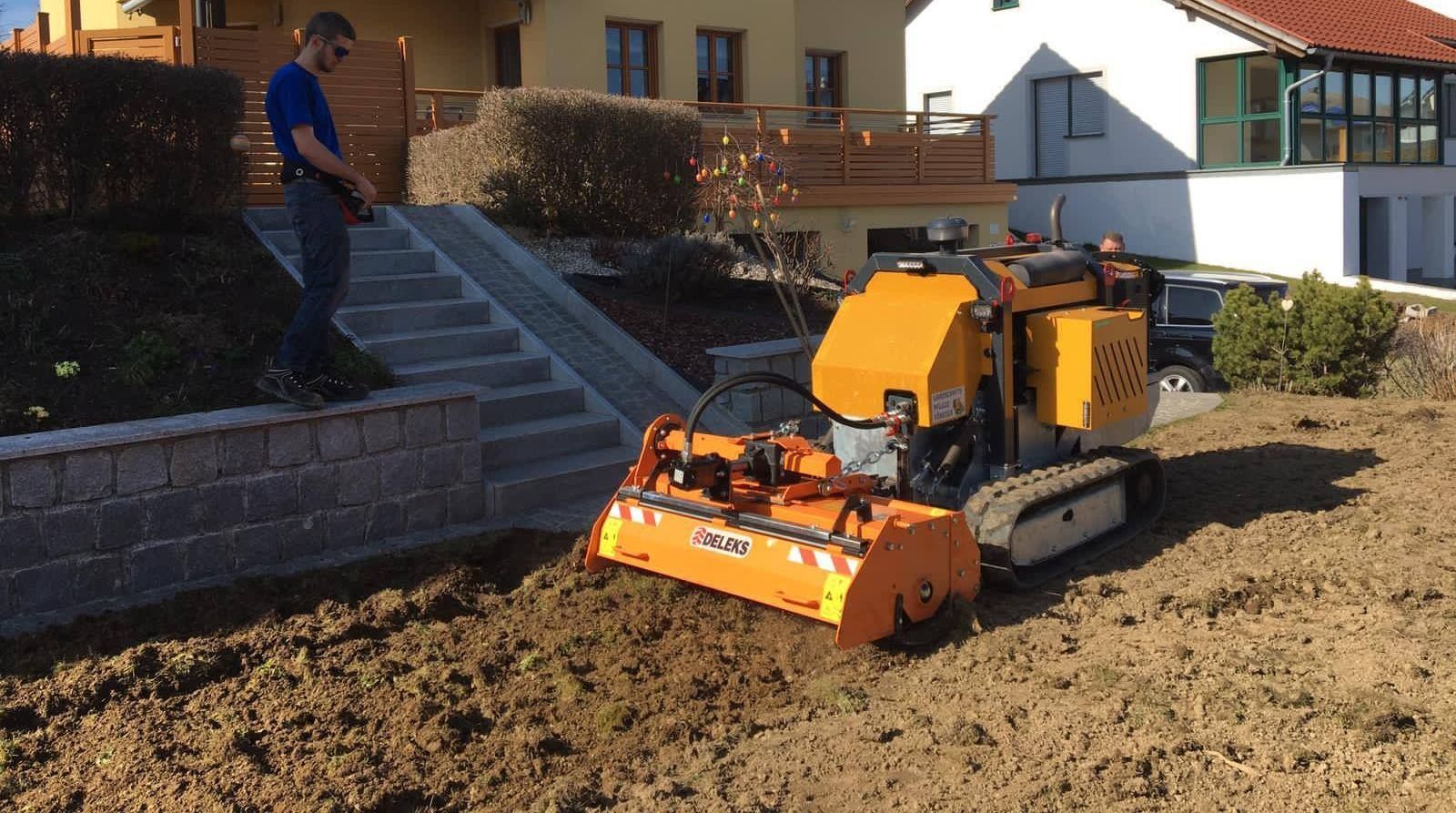 Ein Mann steht neben einem Traktor auf einem Feld.