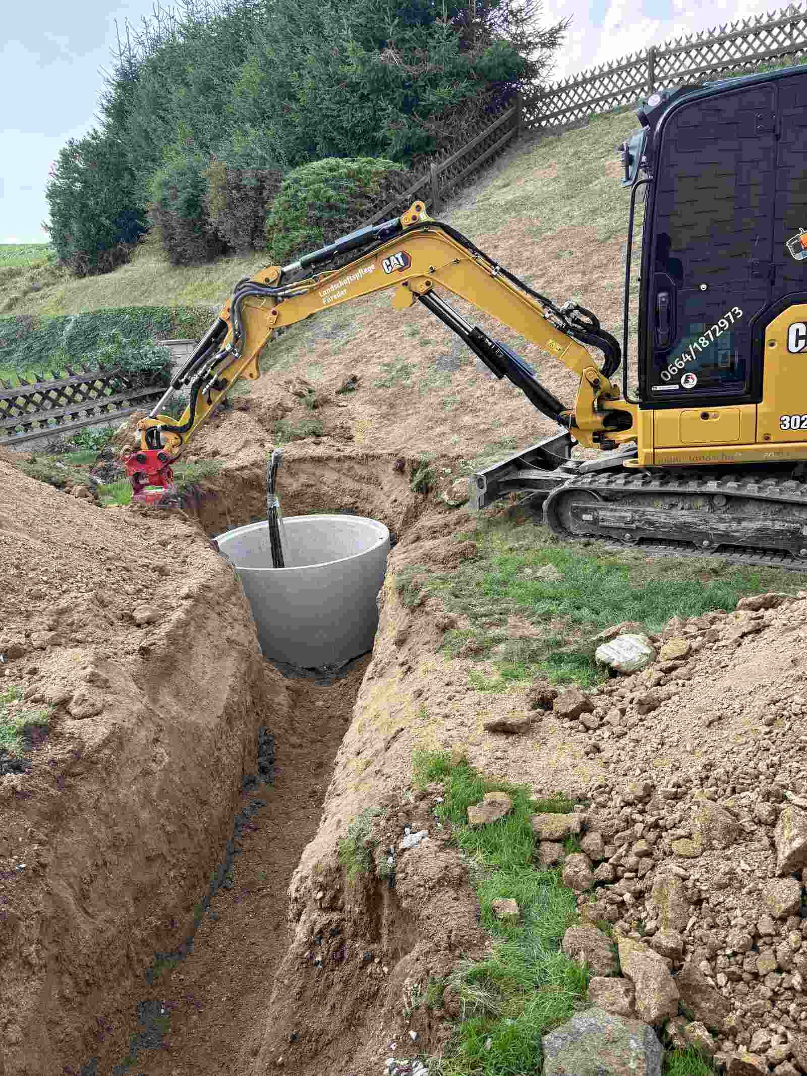 Ein kleiner Bagger gräbt ein Loch in den Boden.