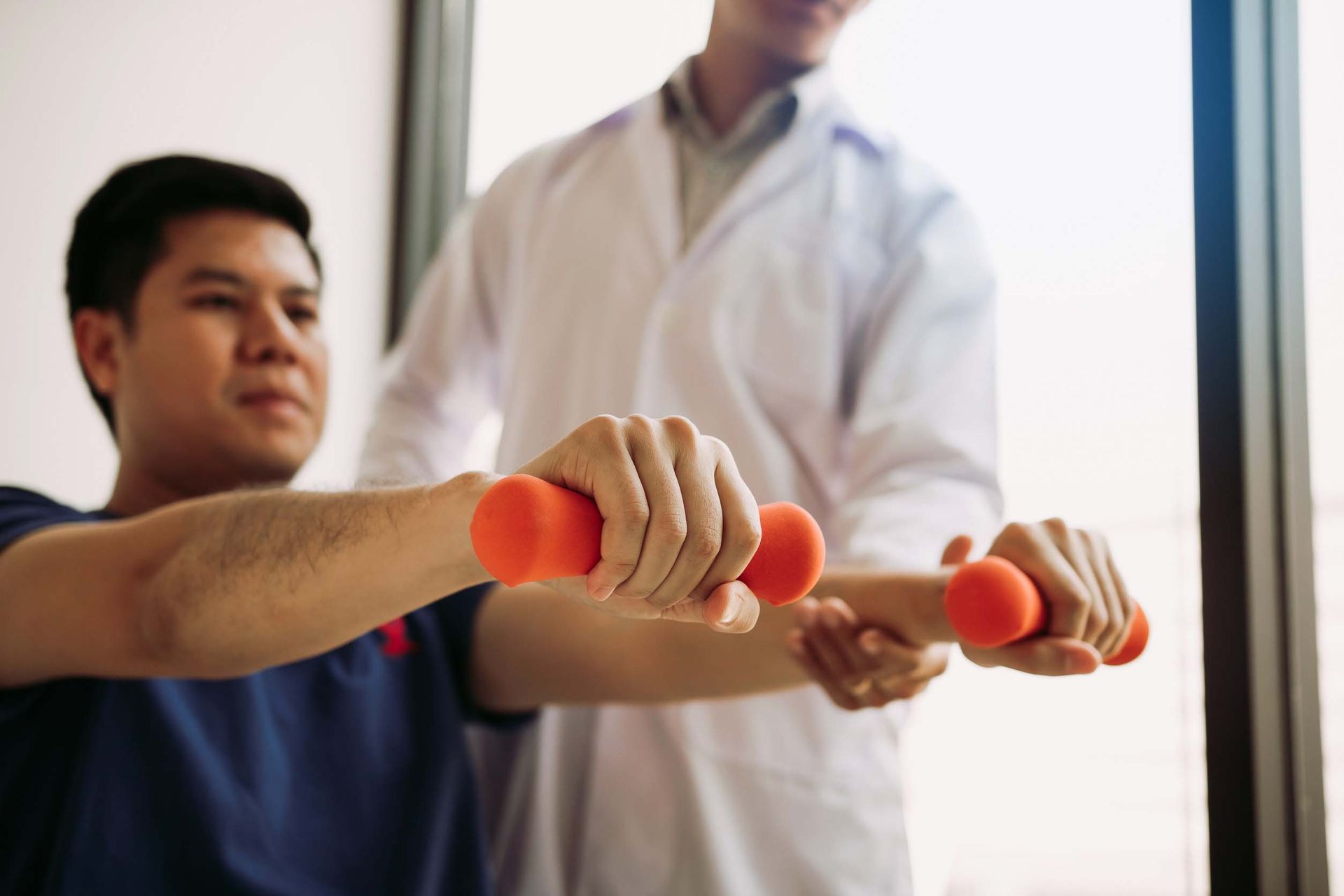 Un médico ayuda a un hombre a levantar pesas.