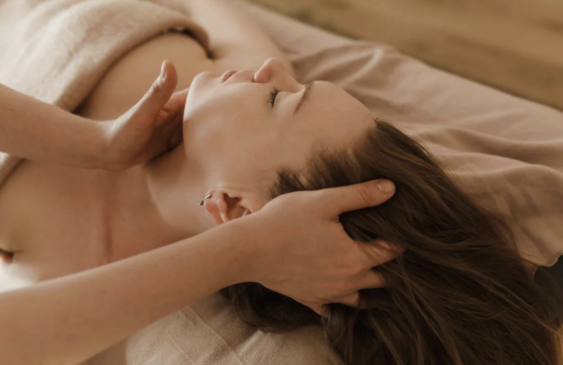 Una mujer está recibiendo un masaje de cabeza en un spa.
