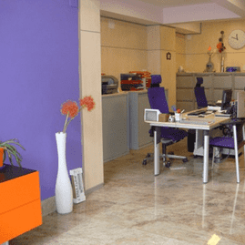 Una oficina con sillas moradas y una pared morada.