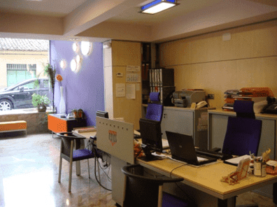 Una habitación con muchos escritorios y sillas.