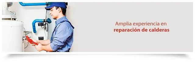 Un hombre con uniforme azul está trabajando en una caldera.