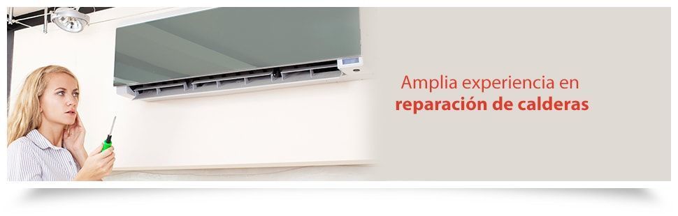 Una mujer sostiene un destornillador delante de un acondicionador de aire.