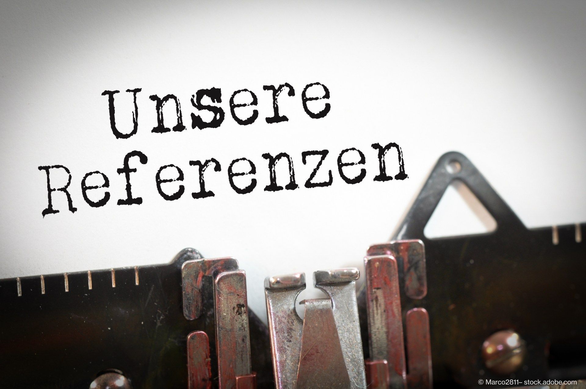 Schild mit der Aufschrift ‚Unsere Referenzen‘ vor technischem Hintergrund