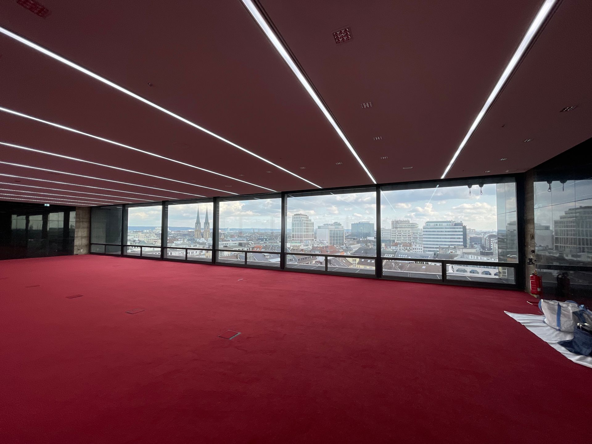 Modernes Büro mit rotem Teppich und Blick auf die Stadt