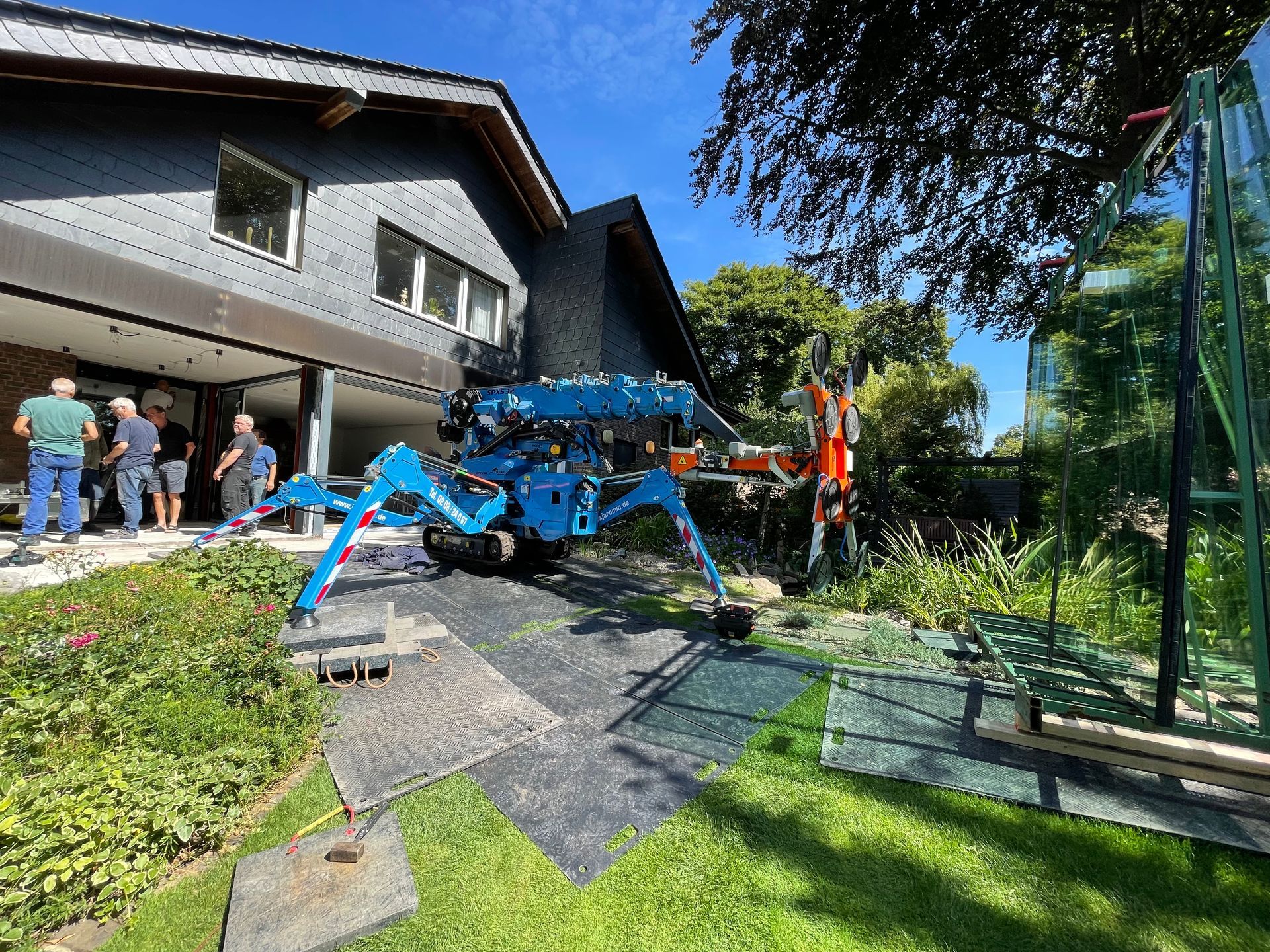 Blauer Kran auf der Baustelle mit Handwerkern