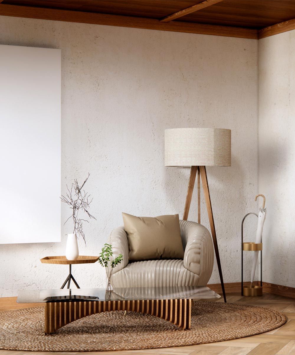 Una sala de estar con una silla, una mesa, una lámpara y una alfombra.