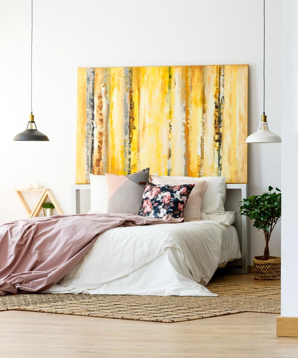 Un dormitorio con una cama y un cuadro en la pared encima.