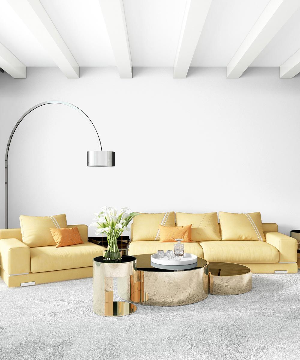 Una sala de estar con un sofá amarillo y dos mesas de café.