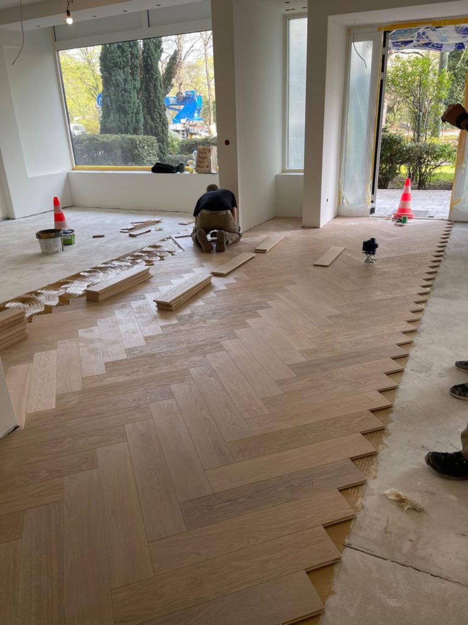 Ein Mann arbeitet in einem Raum an einem Holzboden. Tool Time NRW GmbH