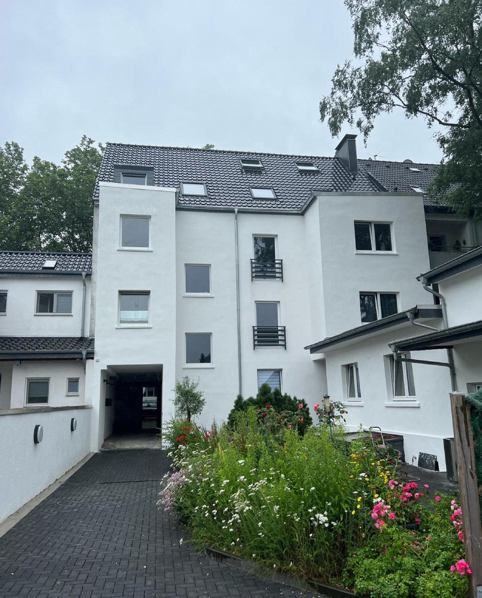 Ein weißes Gebäude mit einer gemauerten Auffahrt, die dorthin führt. Tool Time NRW GmbH