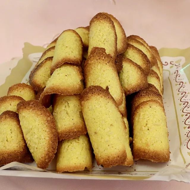 Una pila de galletas en un plato con un fondo rosa.