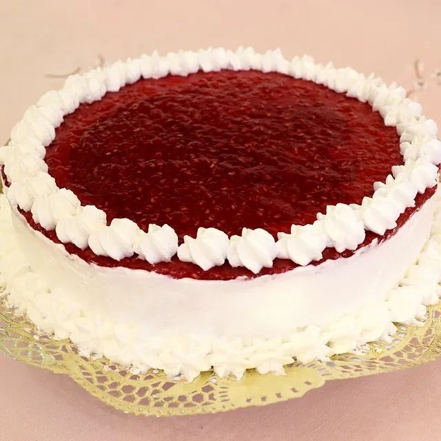 Un pastel de frambuesa con crema batida encima