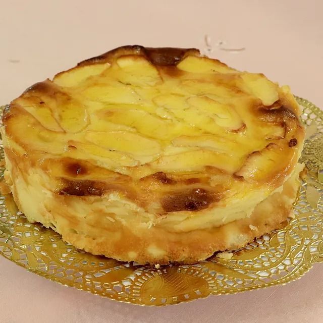 Un pastel de manzana está sentado en un plato dorado sobre una mesa.
