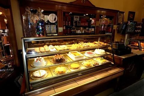 Una vitrina llena de una variedad de postres en una panadería.
