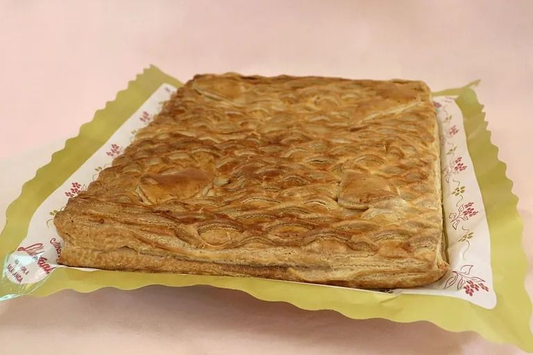 Un gran trozo de pan está sobre una bandeja sobre una mesa.