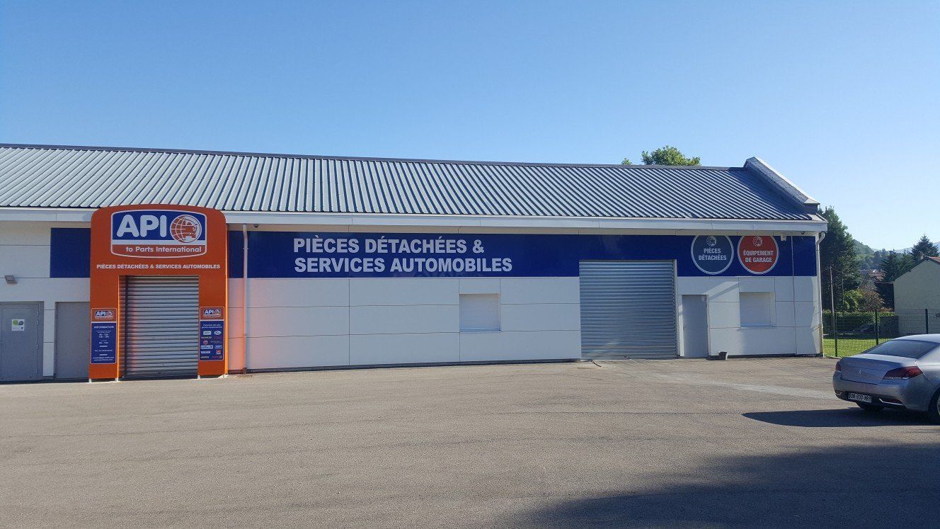 Extérieur d'un bâtiment de pièces et services automobiles avec une enseigne bleue et orange.