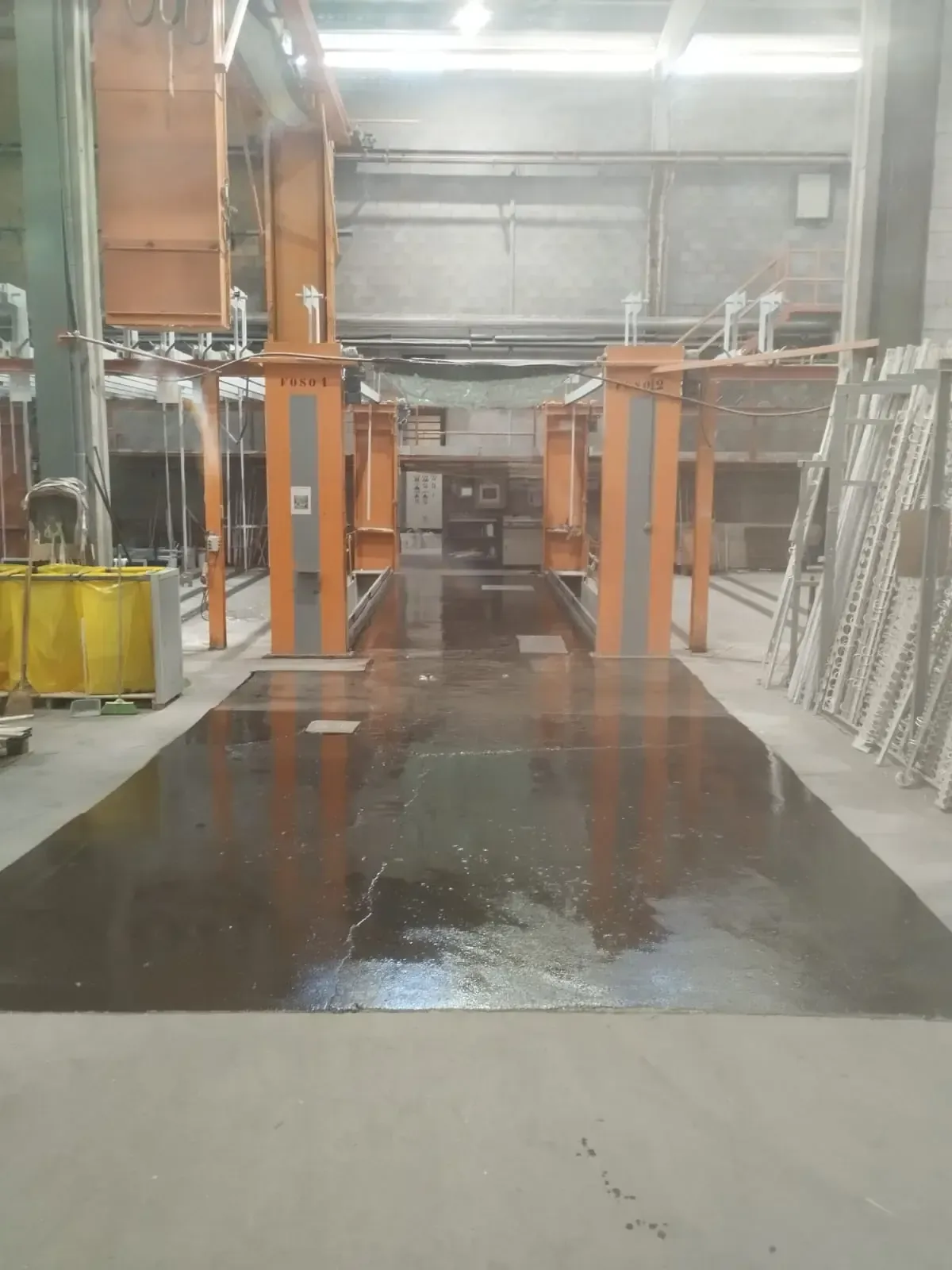 Zonas marcadas con cinta azul dentro de una piscina blanca, una alrededor de una lámpara. El agua del fondo está descolorida.