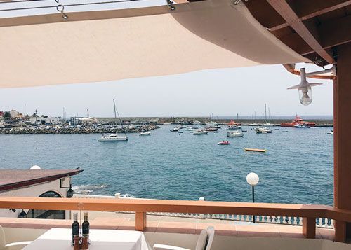 Una vista del océano desde un restaurante con una mesa y sillas.
