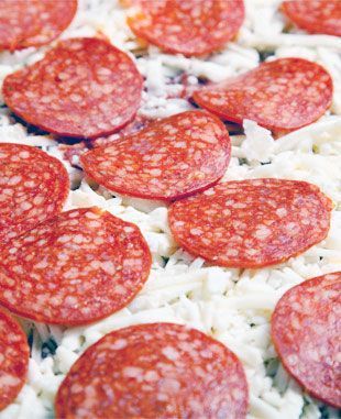 Una pizza con pepperoni y queso encima.