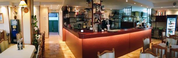 Un restaurante con una barra larga y mesas y sillas.