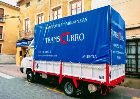 Camión de mudanzas Transcurro azul y blanco estacionado en una calle de Murcia, España.