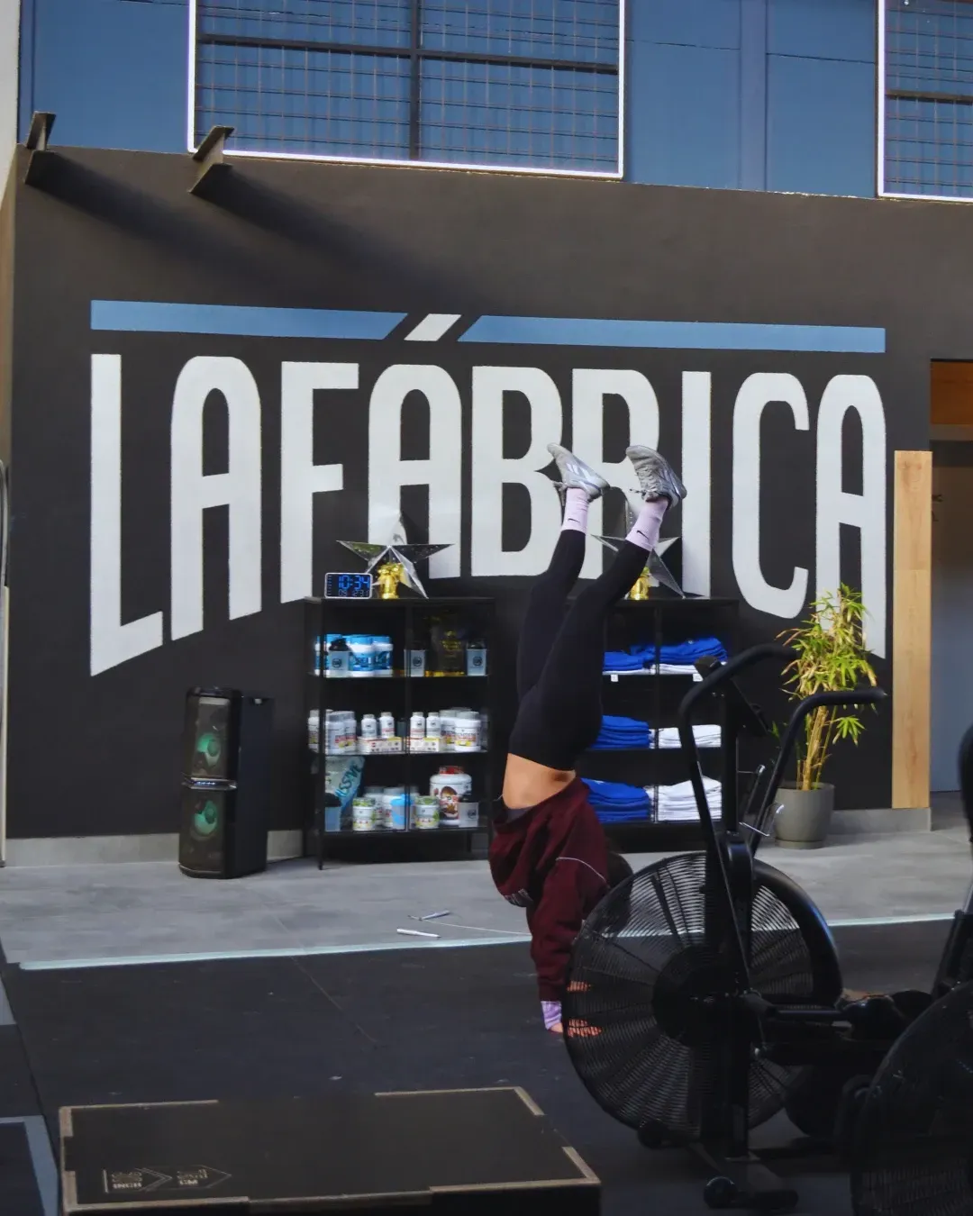 Persona haciendo el pino cerca de un cartel que dice 