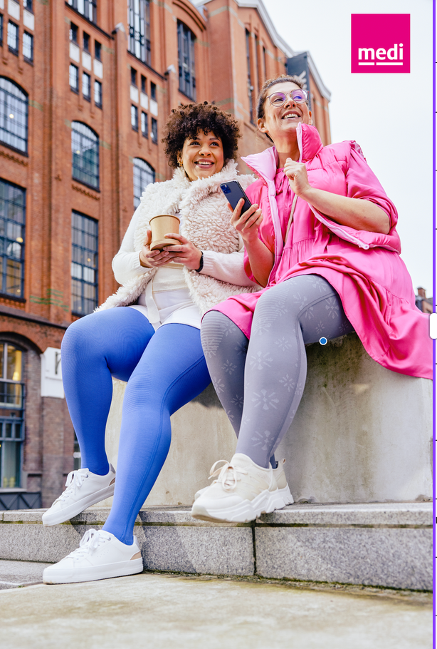 Zwei Frauen sitzen auf einer Mauer