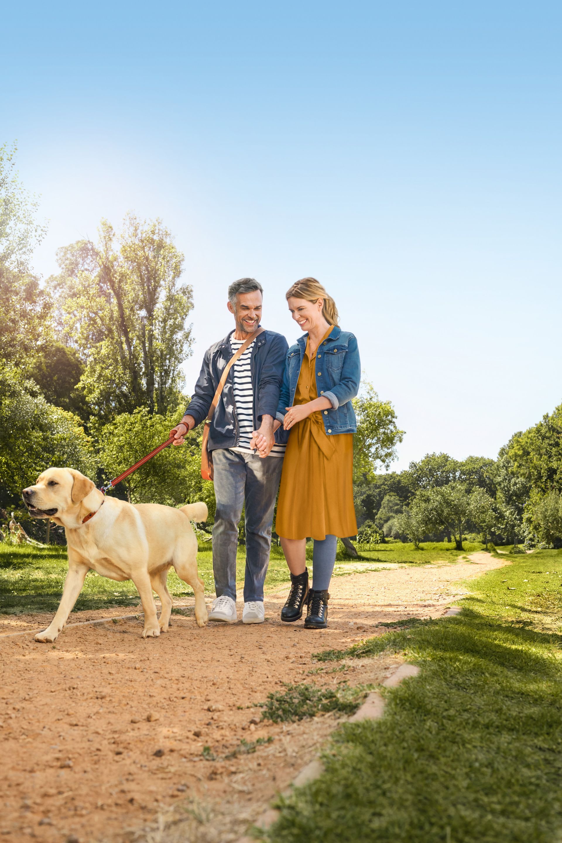 Paar geht mit Hund im Park spazieren