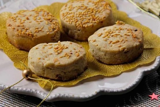 Un plato blanco cubierto con cuatro galletas sobre una servilleta.