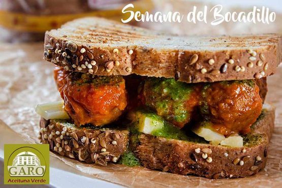 Un sándwich con albóndigas y pesto sobre una rebanada de pan.