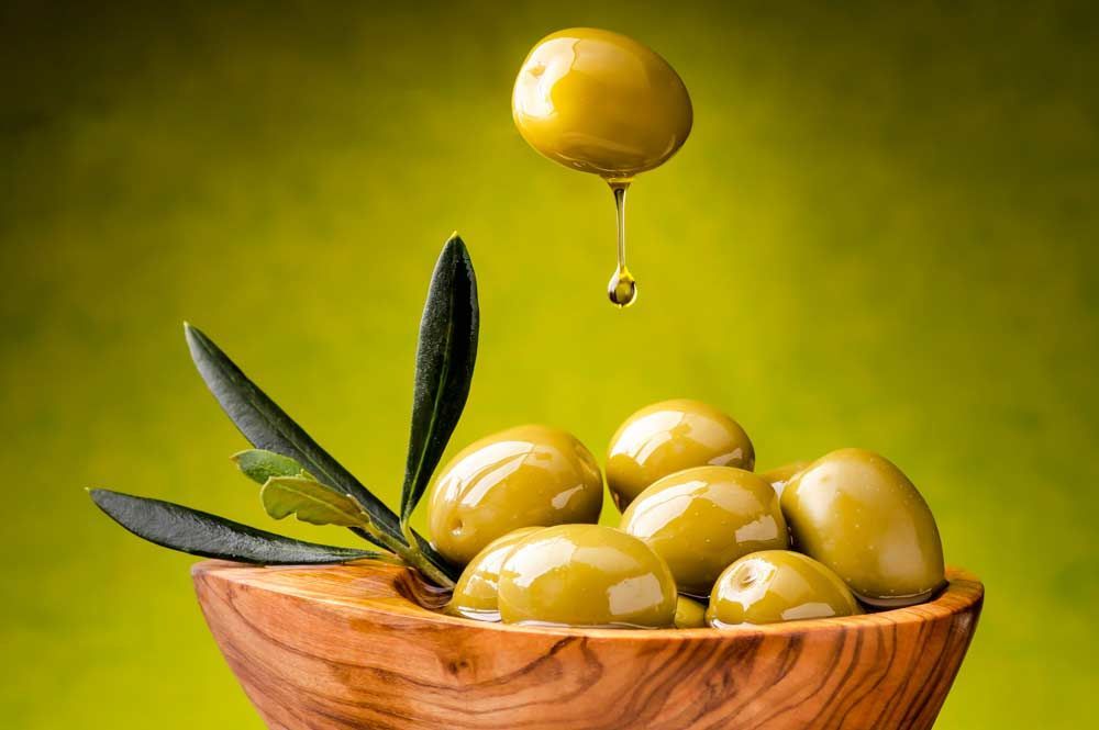 Las aceitunas se vierten en un cuenco de madera.