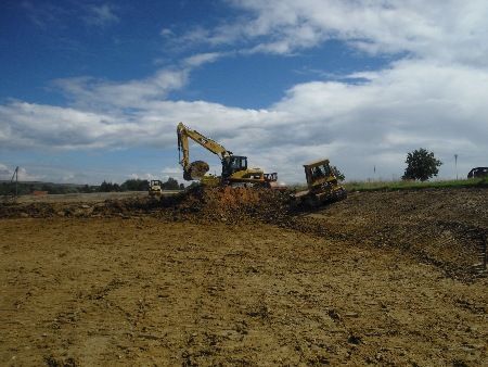 Eine Gruppe Baufahrzeuge arbeitet auf einem Feld.