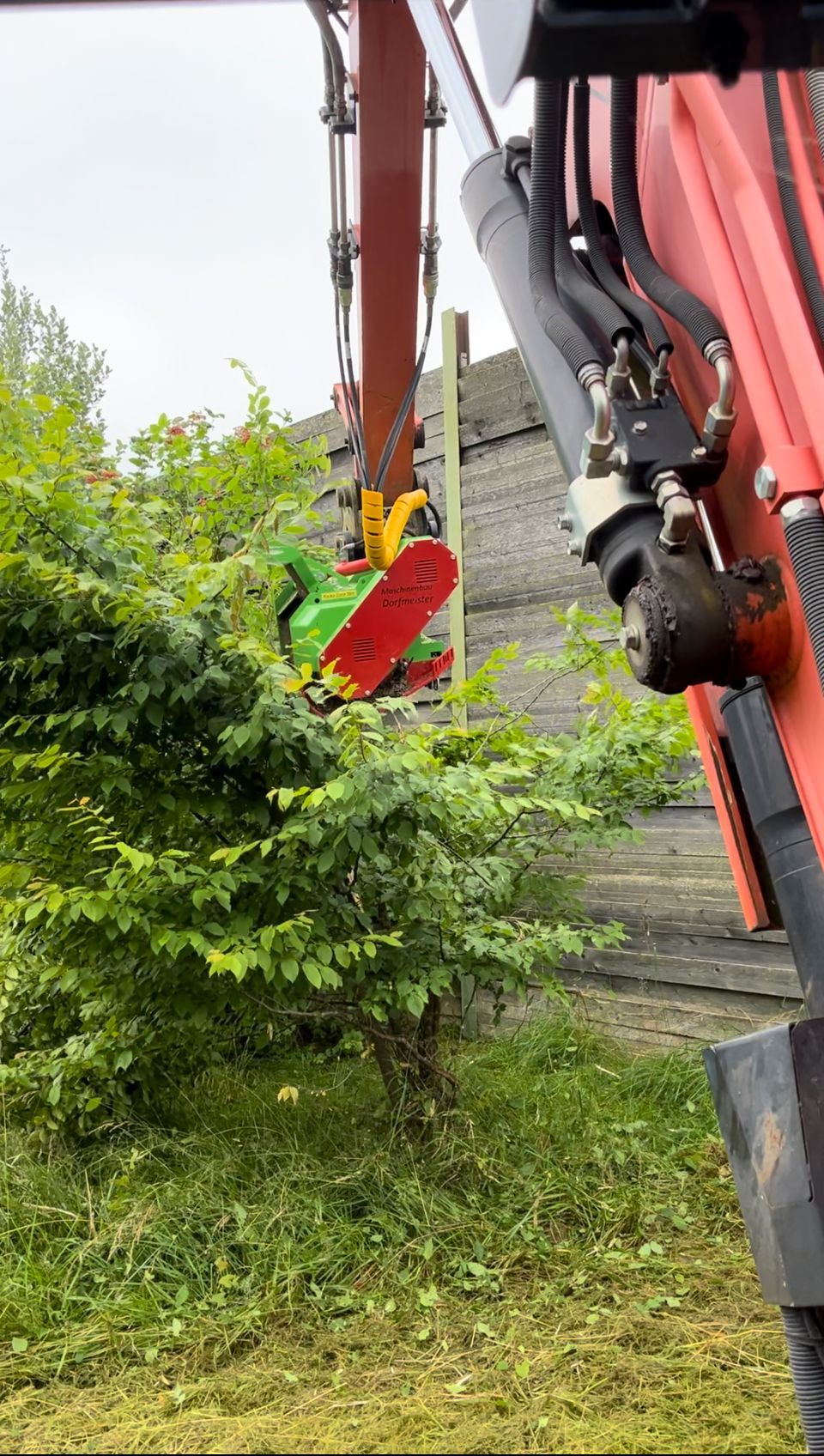 Zwei Bauarbeiter laufen vor einem großen Erdhaufen.