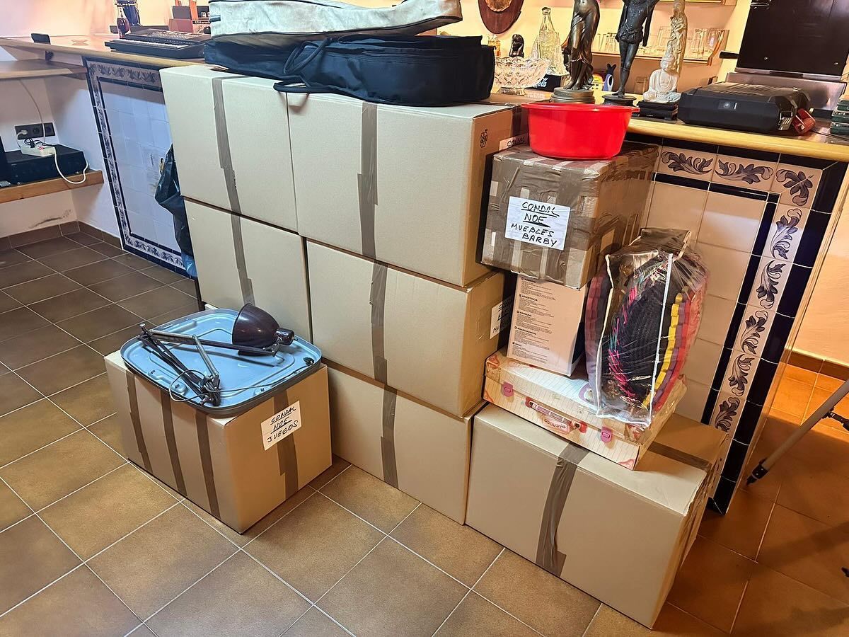 Un montón de cajas de cartón están apiladas una encima de otra en una habitación.