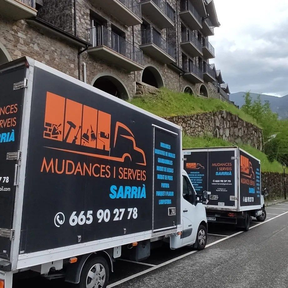 Dos camiones de mudanzas están estacionados frente a un edificio