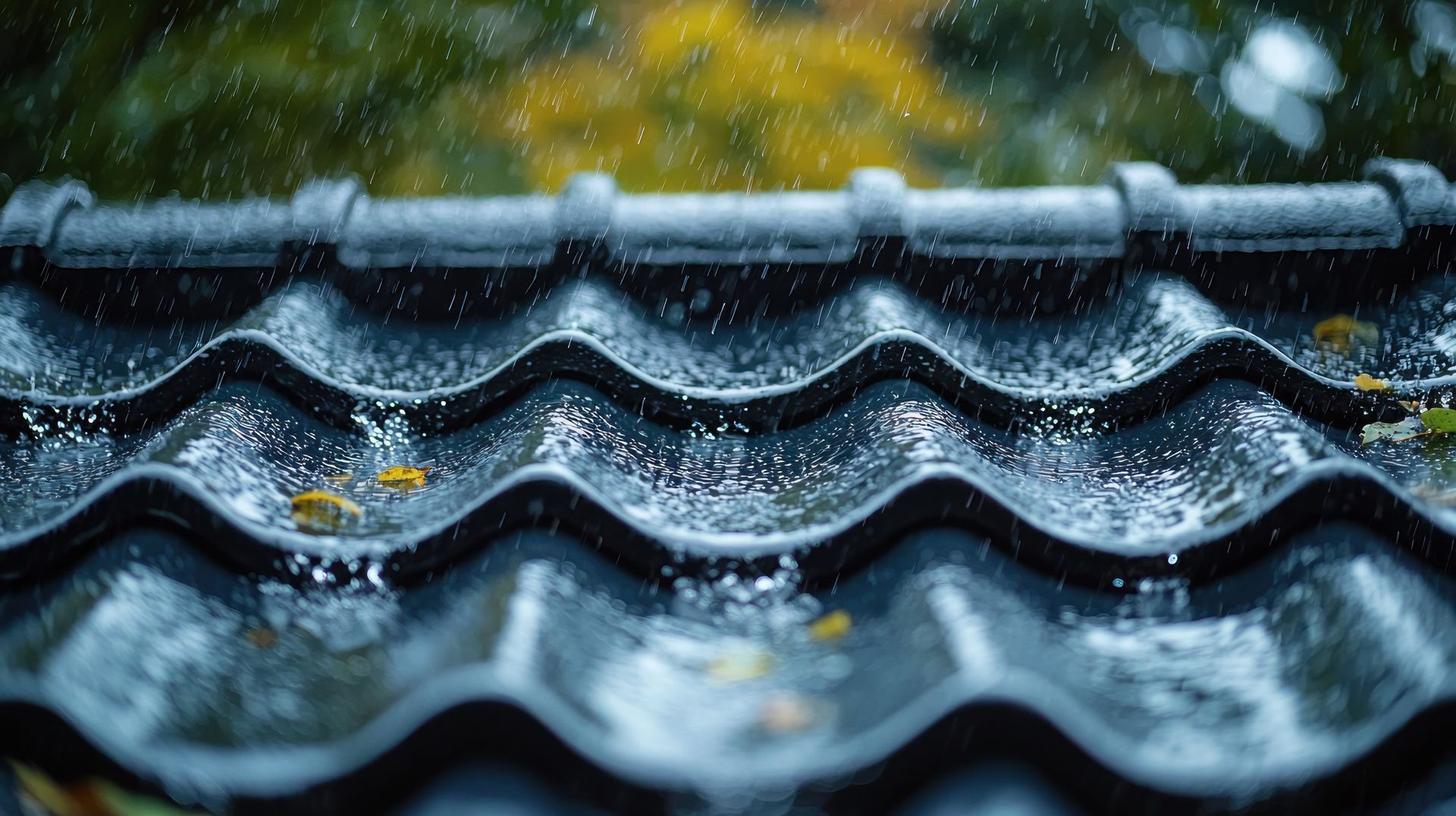 Eau de pluie sur des tuiles de céramique bleu foncé avec des feuilles jaunes entre les arêtes