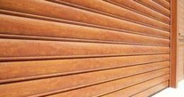 Un primer plano de una puerta de garaje de madera sobre un fondo blanco.