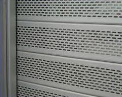 Un primer plano de una persiana metálica con agujeros.