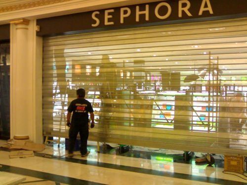 Un hombre está parado frente a una tienda Sephora.