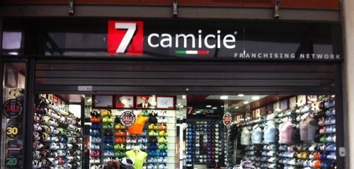 Una tienda llamada 7 camicie tiene muchas camisas en exhibición.