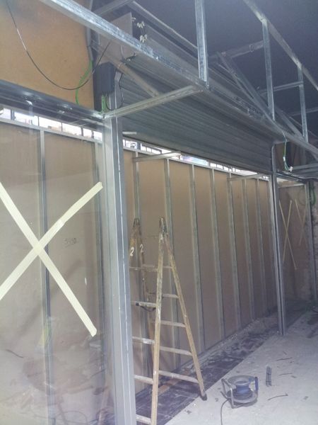 Una escalera está colocada delante de un muro que se está construyendo.