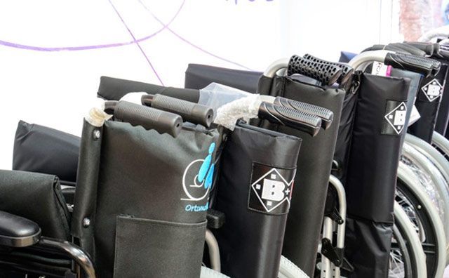 Una fila de sillas de ruedas negras están alineadas en fila.