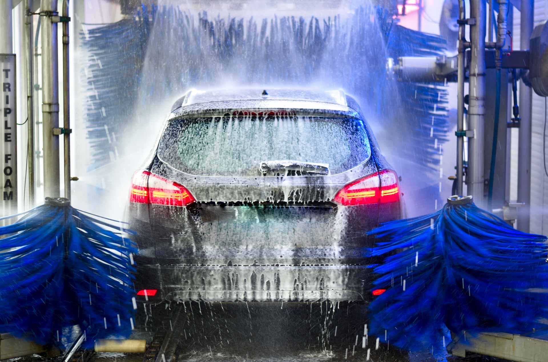 Une voiture vue de dos dans une machine de lavage à rouleaux