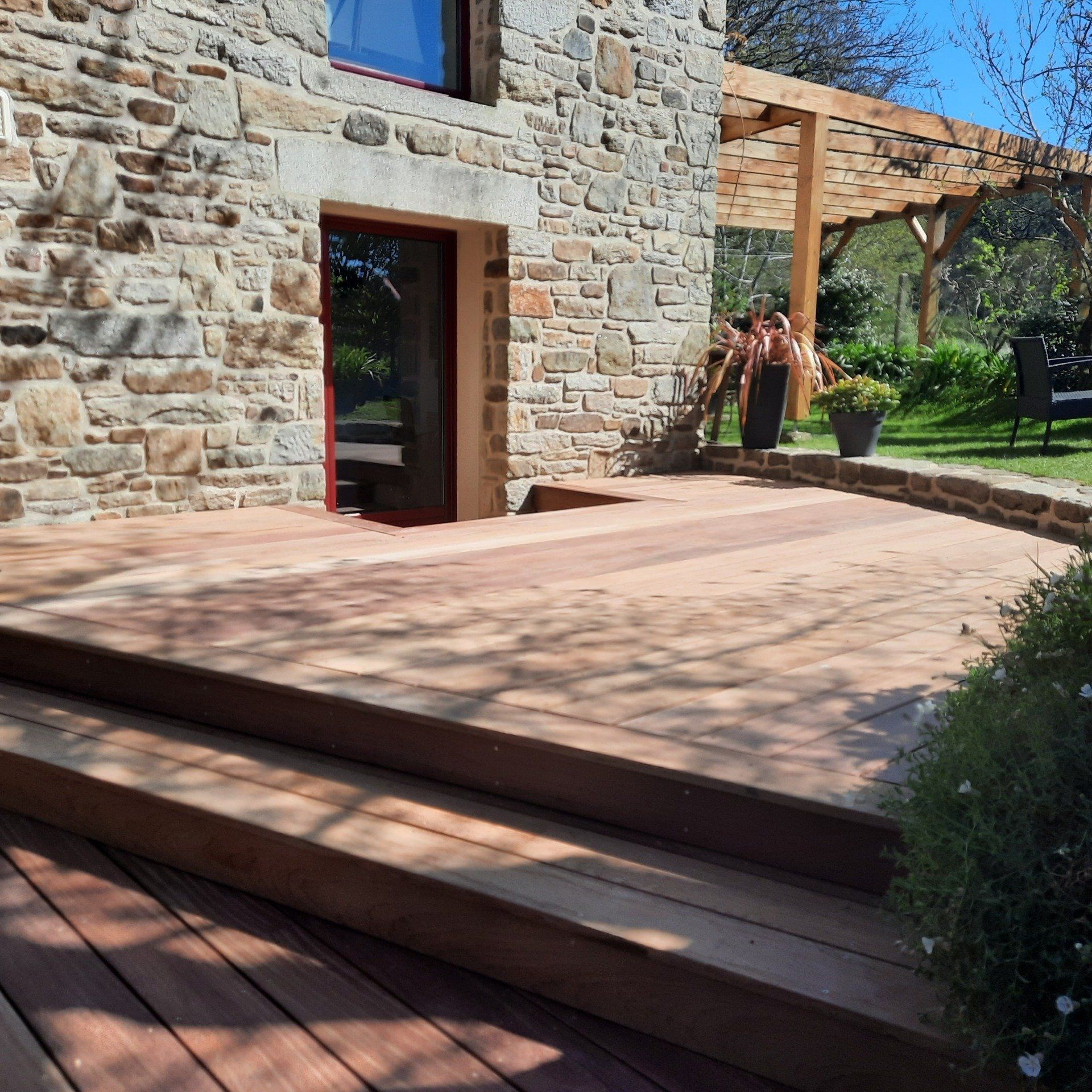 Terrasse en bois et mur en pierre